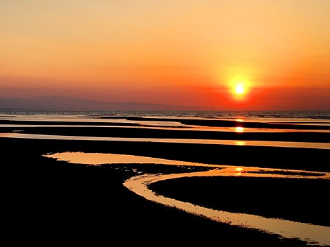 「日本の夕陽百選」の真玉海岸。　単に海に沈むのなら日本海と何が違うんだろう、と思って行ったら、遠浅の海に縞状に潮溜まりができて、そこに反射する夕陽が美しい。
