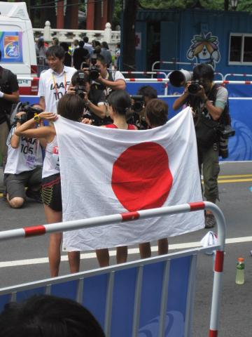 ゴール後、報道陣の要請に応じて、日の丸を背負う、尾崎さん、赤羽さん、中里さん（左から）