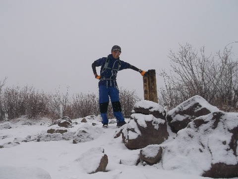 標高１７０４m茅ヶ岳山頂　だんだん雪が強くなってきた。日本百名山の著者の深田久弥氏は昭和４６年３月。茅ヶ岳登山中に急逝。この山が深田氏の終焉の地となる。