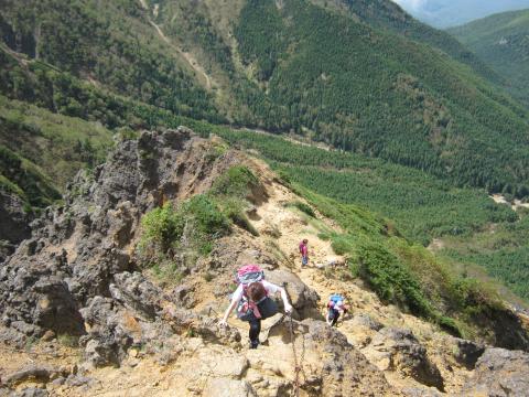 急な鎖場を登る山ガールたち