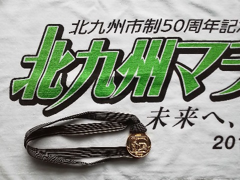 フィニッシャーメダルは,銀河鉄道999のメーテルの横顔が描かれた立派なものですが,もうひとつご紹介したいのはストラップです.これは小倉織,江戸時代には武士の袴や帯として珍重されたのにすたれてしまったのをまた復活させたものだそうです.他の大会では見ないような地味な色の縦じまですが,金色に輝くメダルとの対比が素敵です.