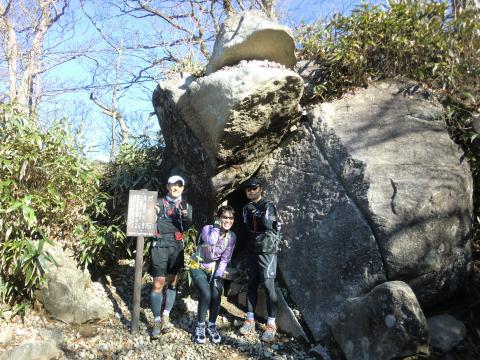 ガマ石前でポーズをとる３人。私も視線は、写真を撮ってくれたカラフルな山ガールに釘付け。