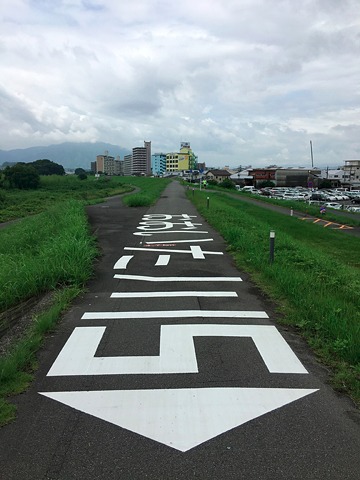 堤防の上には、ヘリなどで上空から川の流れの方向と河口までの距離が分かるように、「おおいた側5」と書かれている。