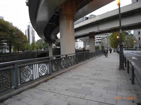 呉服橋の交差点。日銀の向かいだ。昨日までこの首都高速の下に70歳くらいのホームレスがいた。
思えば2年ほど前の朝、身成りが良く上品な老人が大きなバッグを地べたに置いてここに立って居た。通勤途中であった私はこんな朝早くから何をしているんだろうな、と思ったくらいであったが、会社帰りに通りかかったら、まだ同じ姿で立っていた。
何か事情があるのだろうなと思っていたら、次の朝から、彼のホームレスとしての生活がここで始まった。最初はダンボールを敷いて寝ていたが、だんだんと物は増え、まさに「獣の寝床」となっていった。
誰もとがめることなく、一冬を越え、今年の夏も越えた。今年もつらい季節に入ったが、毎朝いるので安心していた。
ところが昨日、突然消えた。きれいさっぱり。
帰りに辺りを良く見たら、彼がしていた老眼鏡が、手すり下に落ちていた。
無事を祈りたい。