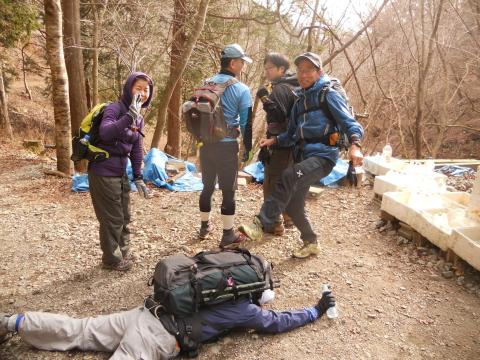 20kgの重さに耐えかねて潰れてしまったヘタレを足蹴にする鬼軍曹。
見て見ぬふりの男衆と、嬉しそうに眺めているJIFU隊員
（撮影：MORI隊員）