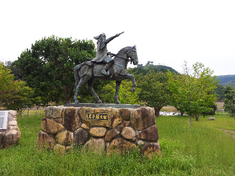 三日月公園の尼子経久像。奥に月山富田城が見える。